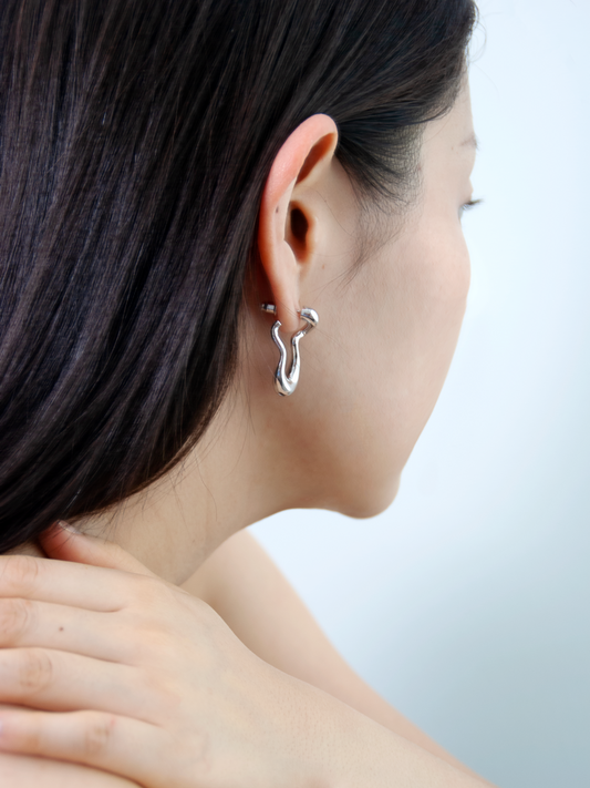 brass earrings worn by model – fluid form jewellery by nood
