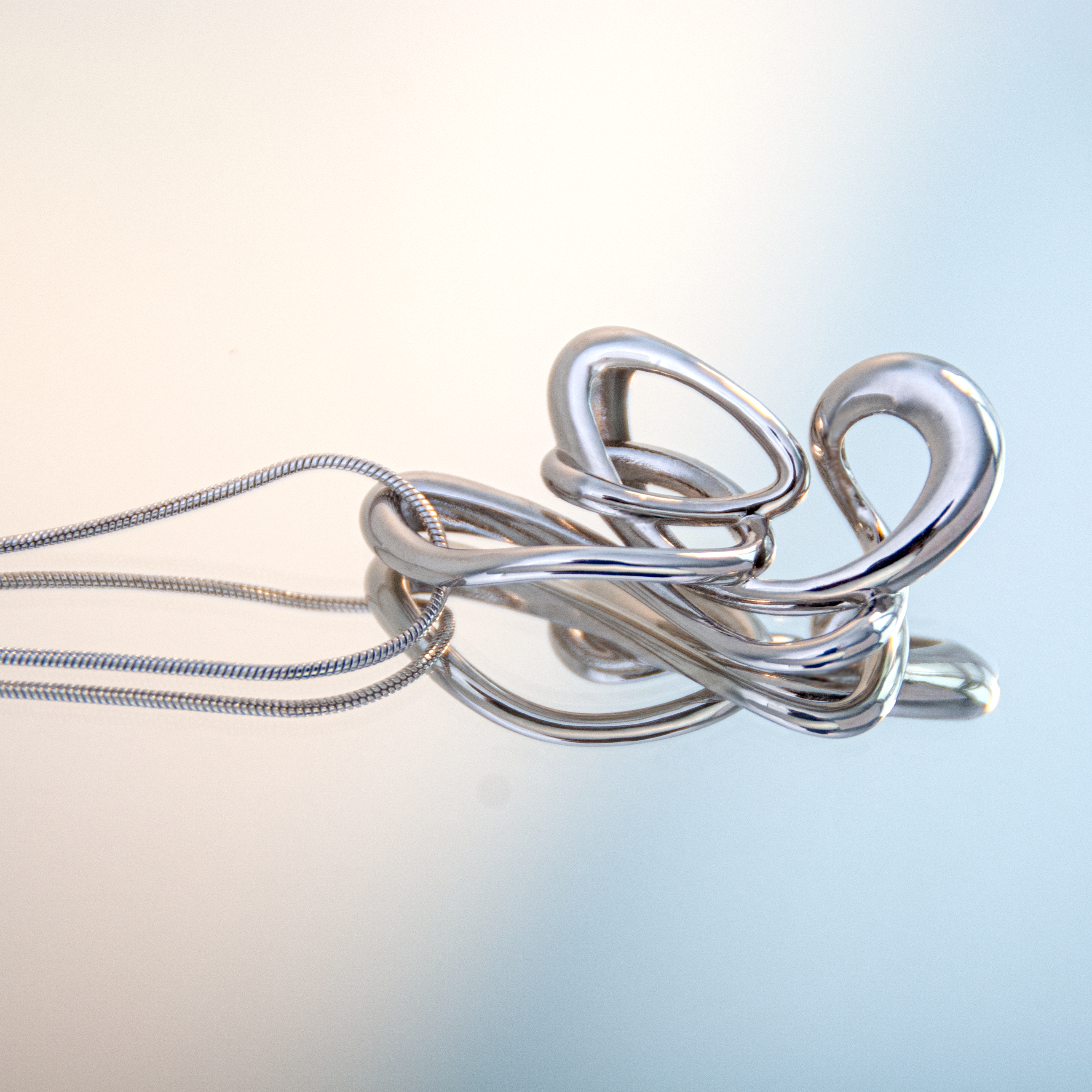 close-up of flicker pendant with snake chain – contemporary sculptural jewellery by nood