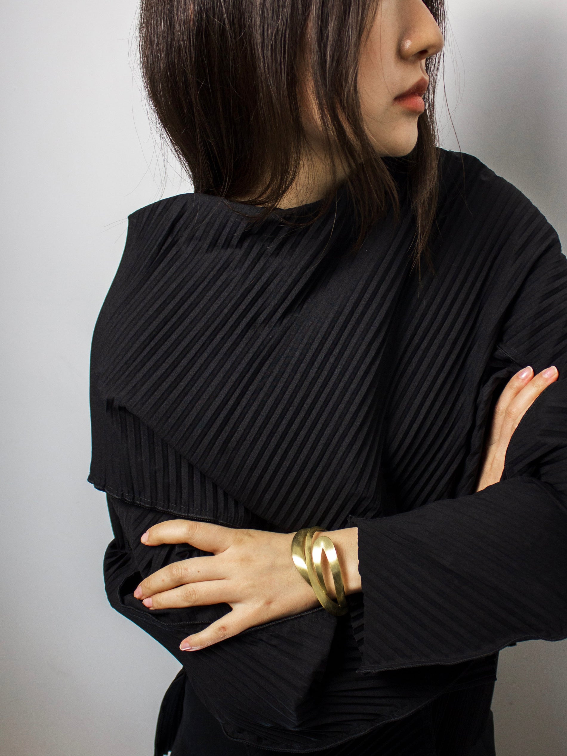 Person wearing a gold sculptural bangle
