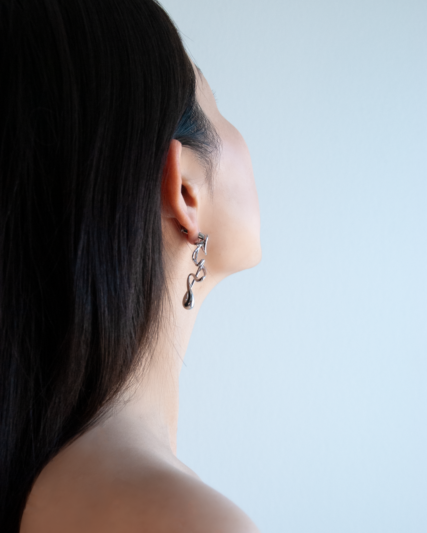silver sculptural earrings in motion – fluid form, brass and rhodium by nood