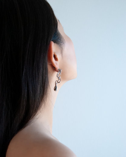 silver sculptural earrings in motion – fluid form, brass and rhodium by nood