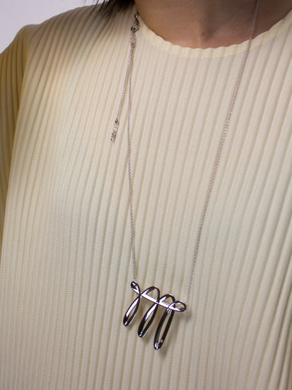 Close-up of nood Lucky Stroke Necklace worn over knitwear, highlighting its flowing sculptural form, turquoise details, and custom clasp