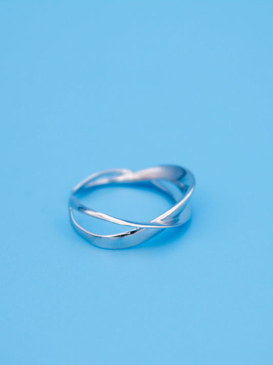 Silver ring with a wavy design on a light blue background