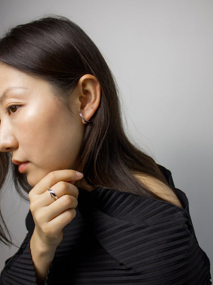 nood Revisit Ring worn as both a ring and ear cuff, featuring a flowing intersecting design, sculptural silver jewelry shaped through 3D modeling