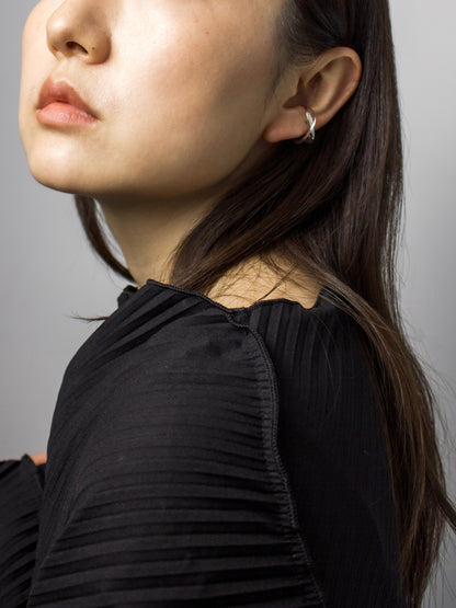 Close-up of nood Revisit Ring worn as a  ear cuff, highlighting its versatile sculptural form and fluid metal surfaces