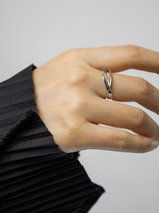 Hand wearing the nood Revisit Ring, a sculptural silver ring with flowing intersecting form, designed through 3D modeling and cast in metal